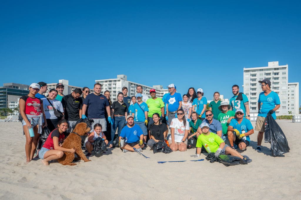 Petland Texas picture of Petland and WOW Center team members standing on Miami beach for beach clean up.