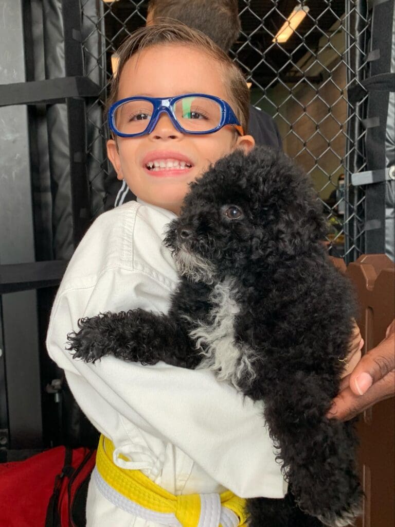 Petland Texas picture of child holding cute Petland puppy at SOFLO Battle of Champions.