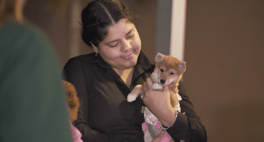 Petland Texas picture of a Petland pet counselor holding a cute Petland puppy at WOW Center Block party.