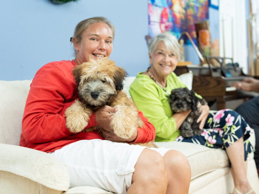 residents of NAMI Center holding cute puppies from Petland Texas.