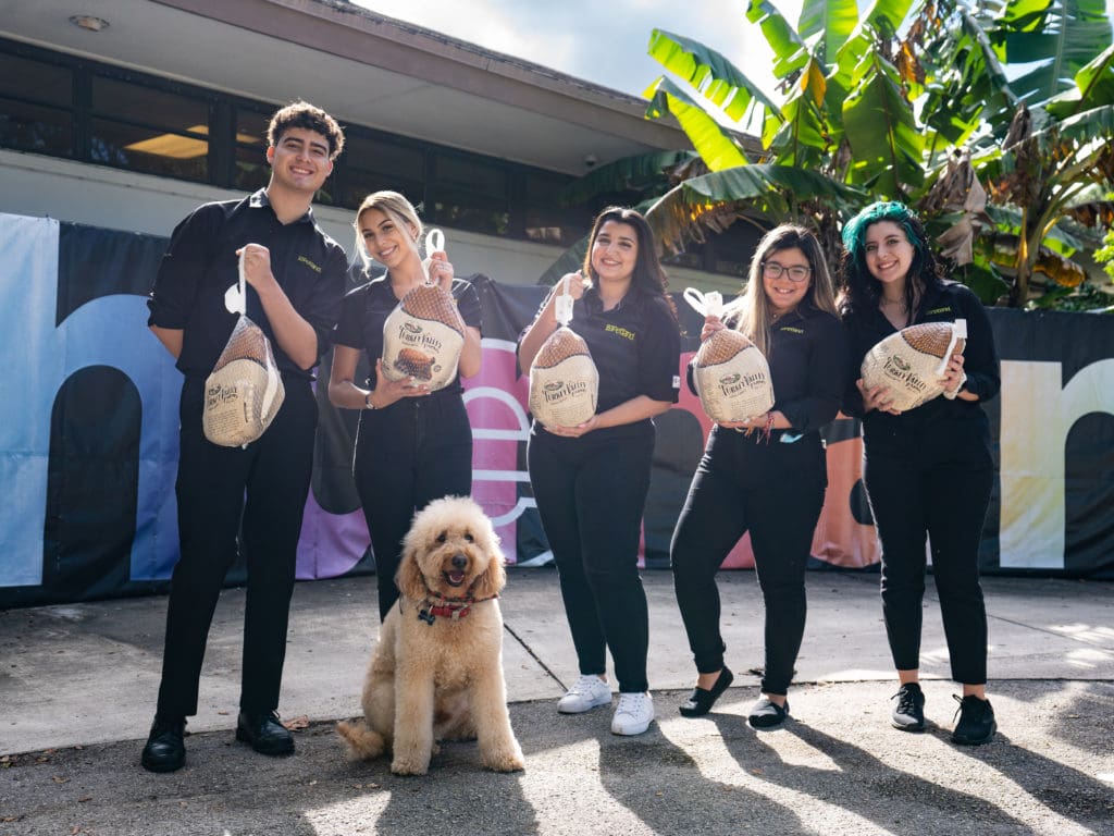 A group of volunteers from Petland Texas standing with turkeys for a donation event at the WOW Center.